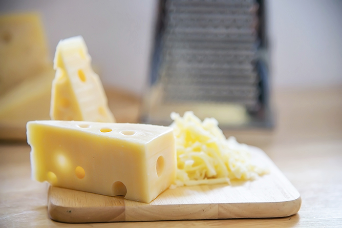Pedaço de queijo em uma tábua de madeira