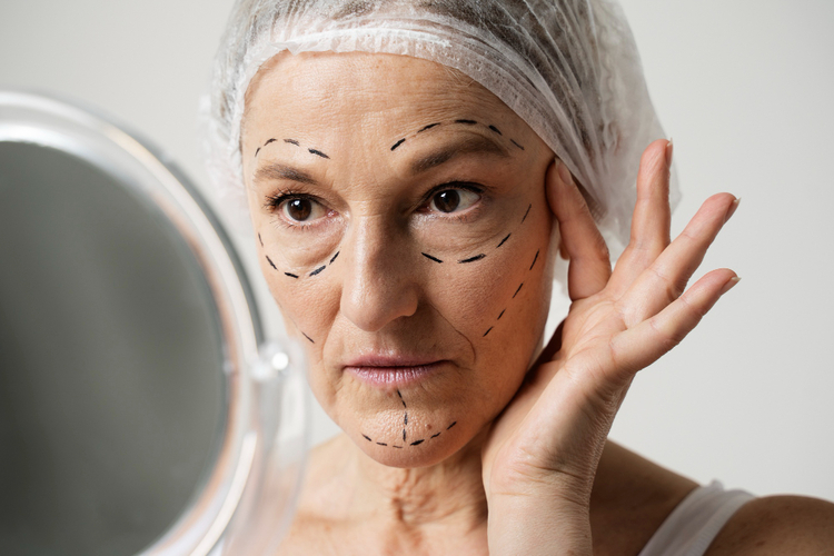 mulher se olhando no espelho e notando o envelhecimento da pele do rosto