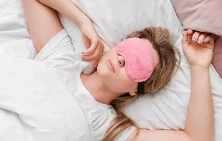mulher usando máscara para dormir com melatonin